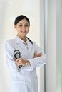 Portrait, Professional Asian female doctor standing in her clinic, holding stethoscope, arms crossed Royalty Free Stock Photo