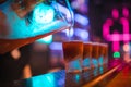 Portrait of professional barman pouring alcoholic digestif in shot glasses at bar.