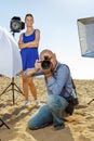 Portrait of professional photographer looking through camera lens during shooting on sunny beach Royalty Free Stock Photo