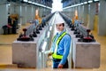 Portrait of professional engineer stand between railroad tracks of electrical or sky train in the factory workplace Royalty Free Stock Photo