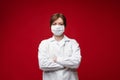 Portrait of professional female doctor in white uniform and protective mask posing isolated Royalty Free Stock Photo