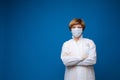 Portrait of professional female doctor in white uniform and protective mask posing isolated Royalty Free Stock Photo