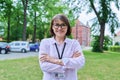 Female educator with card of education center looking at camera outdoor Royalty Free Stock Photo