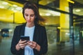 Portrait professional female finance lawyer standing near office in evening street communicates online by cellphone Royalty Free Stock Photo