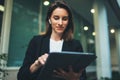 Portrait professional female finance lawyer standing near office in evening street communicates online by tablet. Businesswoman Royalty Free Stock Photo