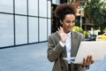 Portrait of professional female financial lawyer standing in front of an office on street communicating online using tablet, Royalty Free Stock Photo