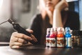 Portrait of professional female tattooist in tattoo studio