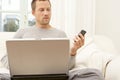 Portrait of professional man with laptop and smart phone at home. Royalty Free Stock Photo