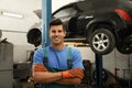 Portrait of professional mechanic near lifted car at automobile repair shop Royalty Free Stock Photo