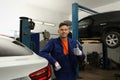 Portrait of professional mechanic near lifted car at automobile repair shop Royalty Free Stock Photo