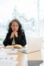 A serious senior Asian businesswoman looking at her laptop screen with a thoughtful, serious face Royalty Free Stock Photo