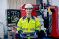 Portrait of professional technician or engineer hold controller and look at camera with smiling stand in front of factory robotic Royalty Free Stock Photo