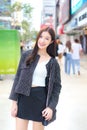 Portrait of Professional young Asian business woman in a black pattern coat with braces on teeth standing and smiling outdoors Royalty Free Stock Photo