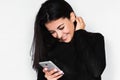 Portrait in profile of attractive young happy woman using smart phone with healthy toothy smile