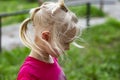 Portrait in profile of pretty blond toddler girl in a windy summer day Royalty Free Stock Photo