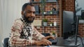 Portrait of programer typing programming code on computer keyboard turning head and smiling