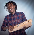 Portrait, prop and happy man holding giant peg looking cheerful on a grey studio background. Face, front and laughing Royalty Free Stock Photo