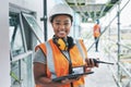 Portrait of proud black construction worker leading with power while managing site logistics on tablet. Happy female