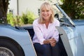 Portrait Of Proud Mature Woman Sitting In Restored Classic Sports Car Outdoors At Home Royalty Free Stock Photo