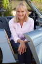 Portrait Of Proud Mature Woman Sitting In Restored Classic Sports Car Outdoors At Home Royalty Free Stock Photo
