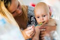 Portrait of mother feeding her baby with spoon Royalty Free Stock Photo