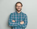 portrait of proud young man with glasses crossing arms and smiling Royalty Free Stock Photo