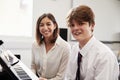 Portrait Of Pupil With Teacher Playing Piano In Music Lesson Royalty Free Stock Photo