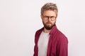 Portrait of puzzled blond bearded man wearing eyeglasses frowning and seriously looking at camera Royalty Free Stock Photo