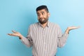 Portrait of puzzled confused bearded businessman shrugging shoulders, uncertain, has no answer. Royalty Free Stock Photo