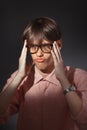 Portrait of puzzled funny young Caucasian man wearing glasses, shirt in a strip siting indoors with happy face and Royalty Free Stock Photo