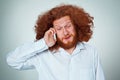 Portrait of puzzled man talking on the phone a gray background Royalty Free Stock Photo