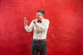 Portrait of puzzled man talking by phone a red background Royalty Free Stock Photo