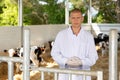 Portrait of a qualified young male veterinarian standing on a livestock farm