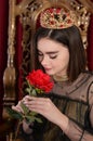 Portrait of beautiful queen sitting on throne with flower