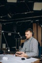 Portrait of radio host using sound mixer on table in studio Royalty Free Stock Photo