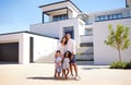 Portrait, real estate and happy family moving into their new luxury home, house or property in summer. Happy parents and