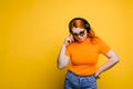 Portrait of a red-haired girl in big headphones and sunglasses. Royalty Free Stock Photo