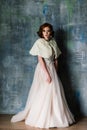 Portrait of red haired girl wearing wedding dress against a white studio background Royalty Free Stock Photo