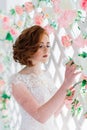 Portrait of red haired girl wearing wedding dress against a white studio background Royalty Free Stock Photo