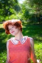 Portrait of a red-haired happy girl in park