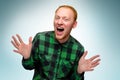 Portrait of red haired happy man show his hands. caucasian male teenager maked surprise. redhead guy scream and laughs