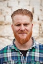 Portrait of red haired hipster man looking at camera