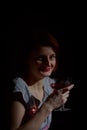 Portrait of red-haired woman with a glass of red wine in the sty Royalty Free Stock Photo