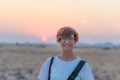 Portrait of a red haired woman with green eyes, eyeglasses and smiling facial expression. Sunset at the horizon. Shot outdoors wit Royalty Free Stock Photo