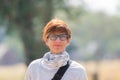 Portrait of a red haired woman with green eyes, eyeglasses and smiling facial expression. Sunset at the horizon. Shot outdoors wit Royalty Free Stock Photo