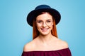 Portrait of red straight-haired attractive cute nice cheerful smiling young girl, wearing spectacles and dark blue hat Royalty Free Stock Photo