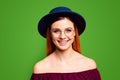 Portrait of red straight-haired attractive cute nice cheerful smiling young girl, wearing spectacles and dark blue hat Royalty Free Stock Photo