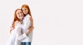 Portrait of redhaired mother and daughter in casual wear look at camera with smile, have good family relationship. Happy