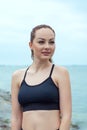 Portrait of a redhead, beautiful, athletic girl with freckles in a black top against the background of the sea, ocean. Outdoor Royalty Free Stock Photo