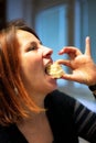 Redhead mature woman biting a peace of tasty cream cake Royalty Free Stock Photo